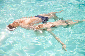 Couple floating in swimming pool