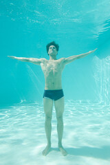 Man posing underwater in swimming pool