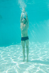 Man posing underwater in swimming pool