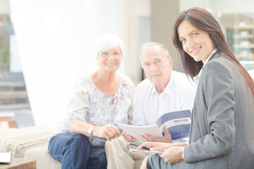 Obraz premium Financial advisor smiling with couple on sofa