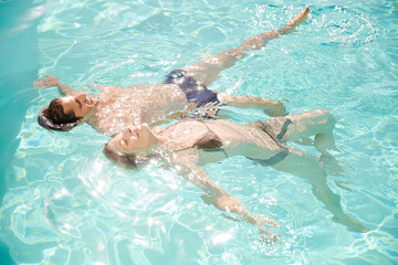 Couple floating in swimming pool