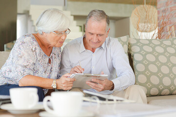 Couple examining blueprints on sofa