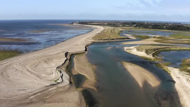 Beautiful Pagham harbour spit entrance in Southern England at low tide aerial video with the nature reserve in view in this haven for wildlife.