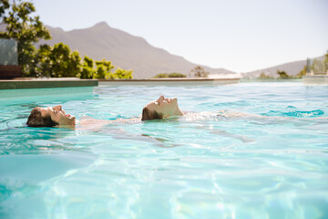 Couple floating in swimming pool