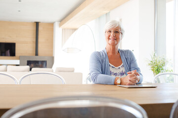 Older woman using tablet computer at table