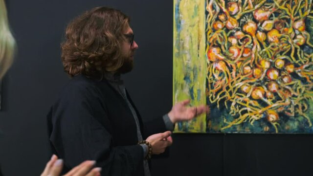 art critic is speaking about picture of modern artist in museum, art excursion