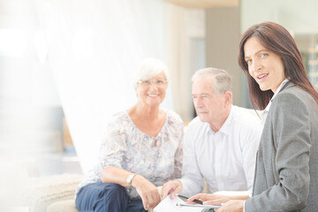Obraz premium Financial advisor smiling with couple on sofa