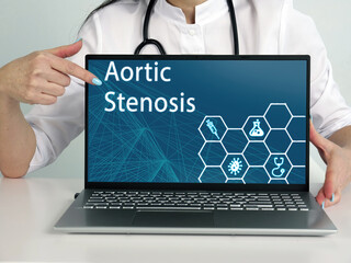  Aortic Stenosis text in list. Hematologist looking for something at laptop.