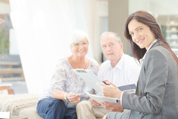 Obraz premium Financial advisor smiling with couple on sofa