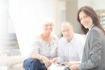 Fototapeta premium Financial advisor smiling with couple on sofa