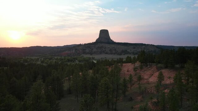 Devil's Tower National Monument at Sunset. Drone video flying low over trees with Devil's Tower in the distance.