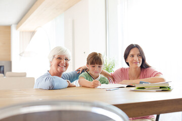 Mother  and grandmother helping girl with homework