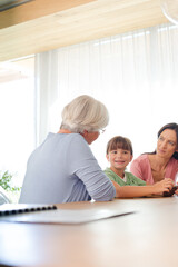 Fototapeta premium Three generations of women using tablet computer