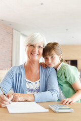 Fototapeta premium Older woman and granddaughter using calculator