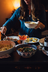 person holding a bowl of food and serving spaghetti pasta meal friends 