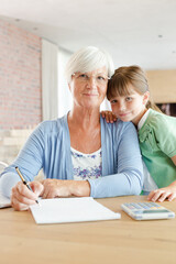 Fototapeta premium Older woman and granddaughter using calculator