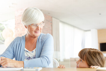 Obraz premium Older woman and granddaughter using calculator