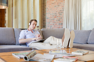 Man using headphones on sofa