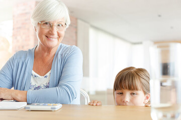 Older woman and granddaughter using calculator