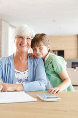 Obraz premium Older woman and granddaughter using calculator