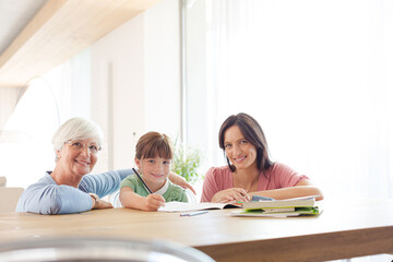 Mother  and grandmother helping girl with homework