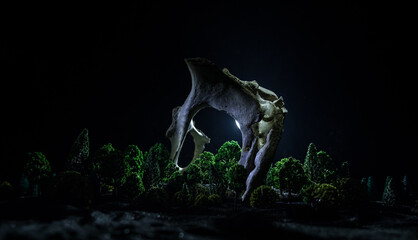 Fototapeta premium Animal bone in dark Halloween night with fog and light on background / Selective focus and space for text. Abstract horror concept