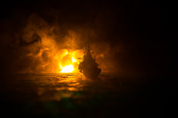 Silhouettes of a crowd standing at blurred military war ship on foggy background. Selective focus.