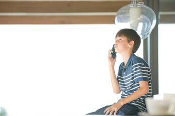 Boy using smartphone in modern house