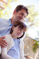 Father and daughter outdoors, smiling