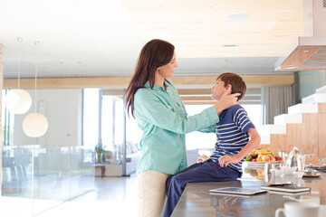 Mother and son smiling in kitchen