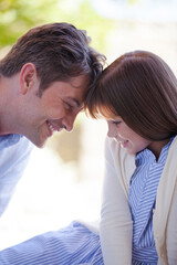 Father and daughter touching foreheads outdoors