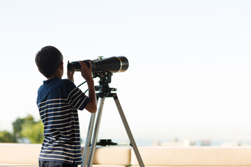 Boy using telescope outdoors