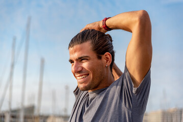 Fototapeta premium Young latin man stretching after doing exercise outdoors