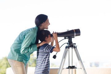 Mother and son using telescope