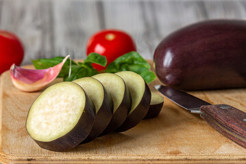 Fresh eggplant slices lie on a cutting board. Close-up.