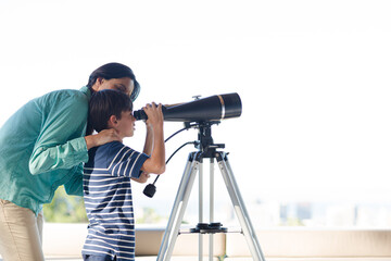 Mother and son using telescope