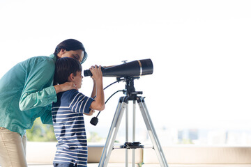 Mother and son using telescope