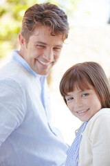 Father and daughter smiling outdoors