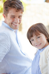 Father and daughter smiling outdoors