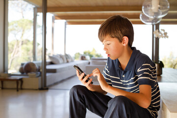 Boy using cell phone on steps