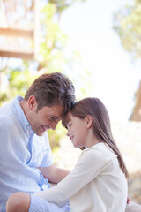Obraz premium Father and daughter touching foreheads outdoors