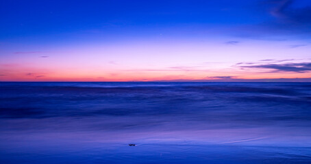 Obraz premium Beautiful motion blur long exposure sunset or sunrise with dramatic sky clouds over calm sea in tropical phuket island Amazing nature view and light of nature seascape.