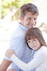 Father and daughter hugging outdoors