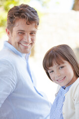 Father and daughter smiling outdoors