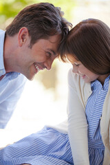 Father and daughter touching foreheads outdoors