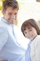 Father and daughter smiling outdoors