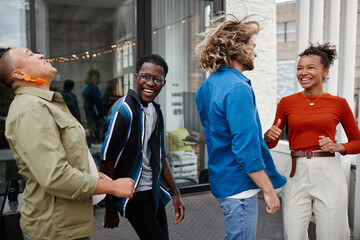 Diverse group of young people dancing and having fun while enjoying outdoor party at rooftop