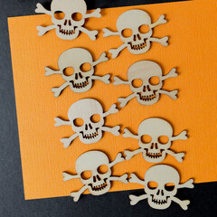 halloween theme with wooden shapes on orange and black paper background with space