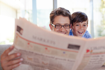 Father and son reading newspaper together