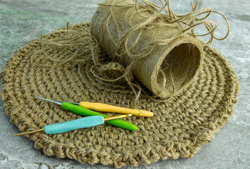 Handicraft kit. Crochet hooks and threads on a knitted napkin.